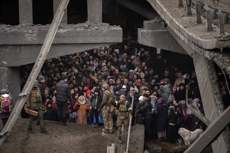 Ukrainians crowd into a bombed building, as they try to cross the border.