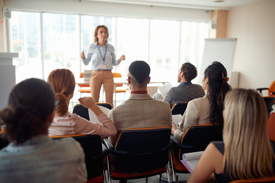 Female lecturer standing at the front of a university class