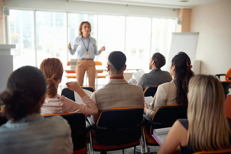 Female lecturer standing at the front of a university class