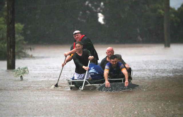 four people in a boat during flood