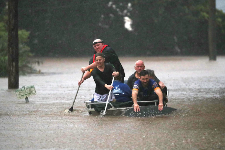 four people in a boat during flood