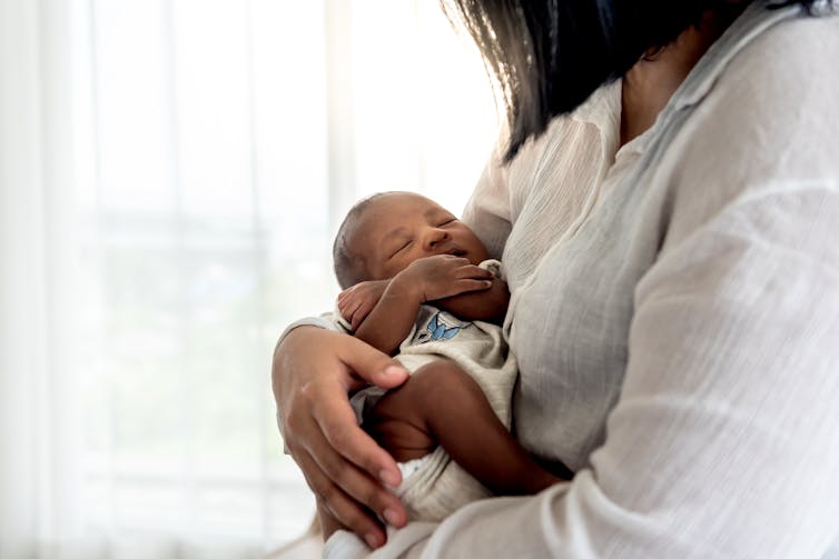 woman holds very young baby close