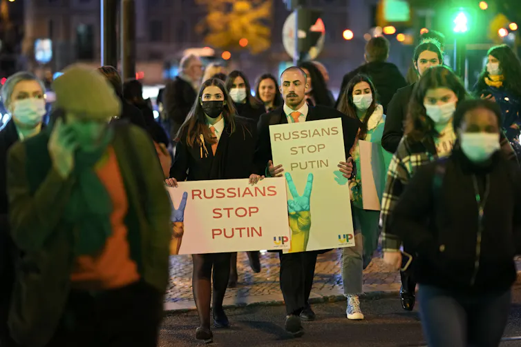 People seen carrying posters reading 'Russians stop Putin'
