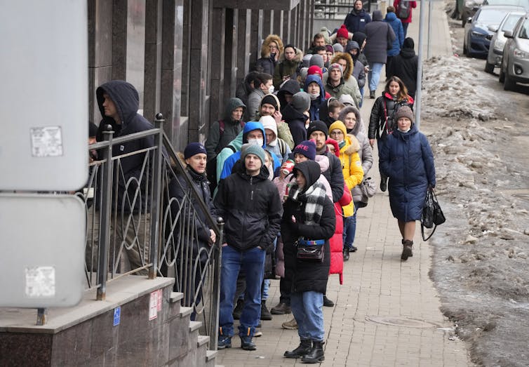 People standing in line on a sidewalk