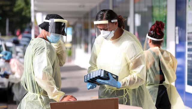 Public health staff at a testing station, getting rapid antigen test kits  ready