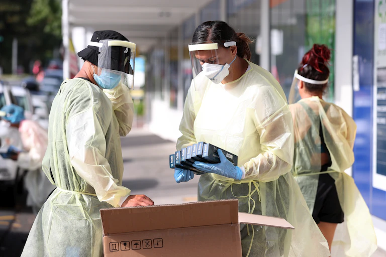 Public health staff at a testing station, getting rapid antigen test kits ready