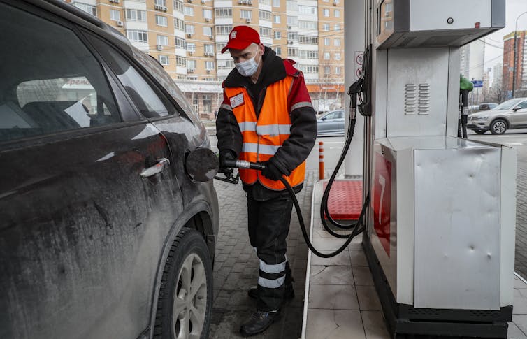 A worker filles up a car at a Lukoil petrol station in Moscow.