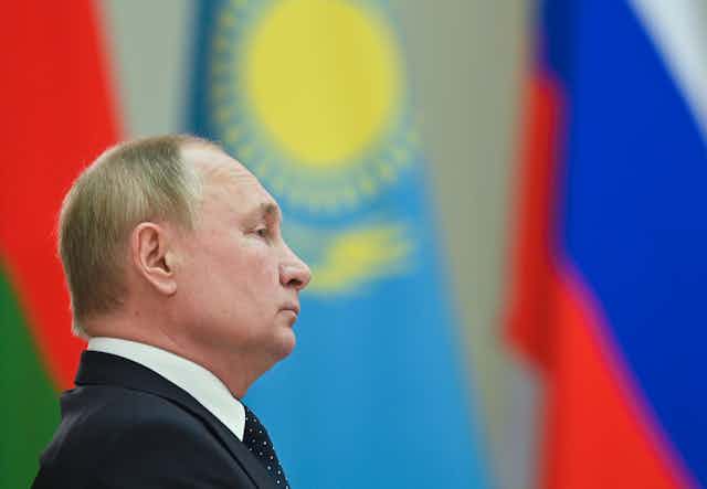 Perfil de Vladimir Putin con varias banderas internacionales de fondo.