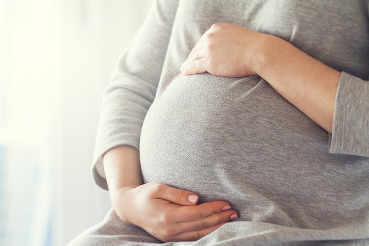 A pregnant woman holding her bump