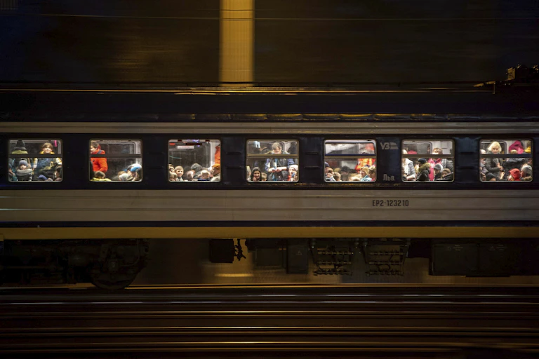 A train filled with Ukrainian refugees seen looking out the windows.