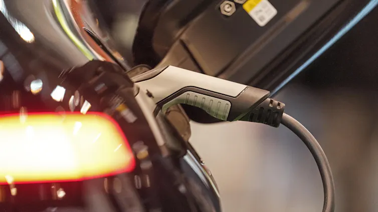 A close up of an electric car being charged.
