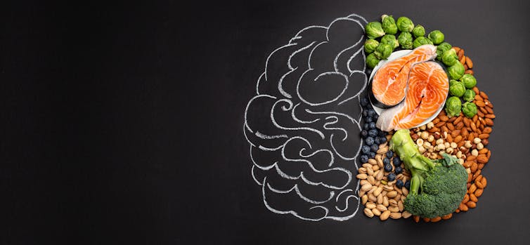 A chalk drawing of a brain on a blackboard, with the right half of the brain filled in with healthy foods