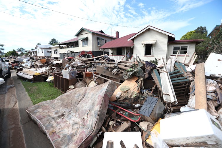 home with flood debris in front