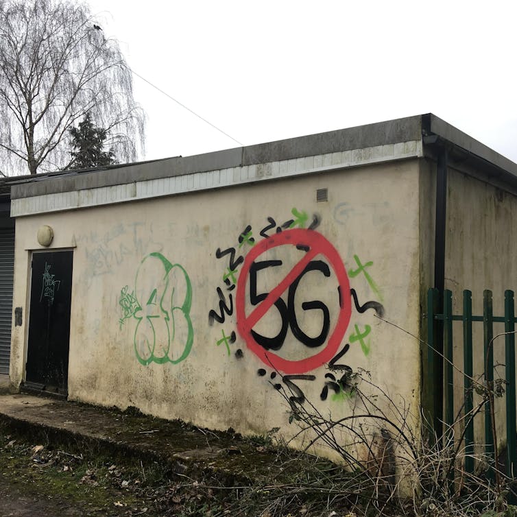 An anti-5G graffiti on an outdoor wall in an urban context.