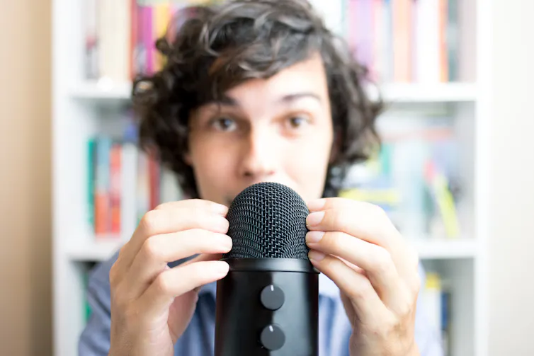 Man runs fingers along microphone