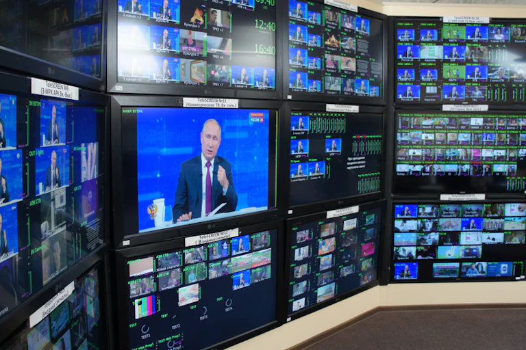 Many television screens showing President Putin speaking