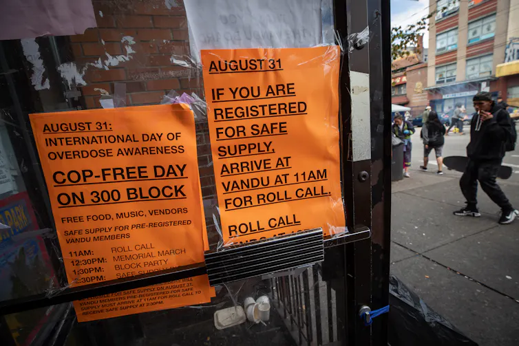 Orange signs with black block lettering instructions on how to pick up safe supply of illicit drugs.