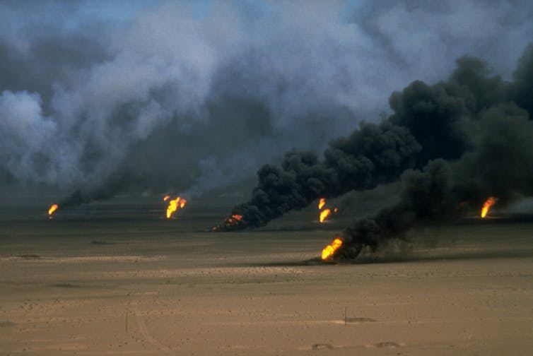 Smoke and flames rising from eight oil wells in the desert