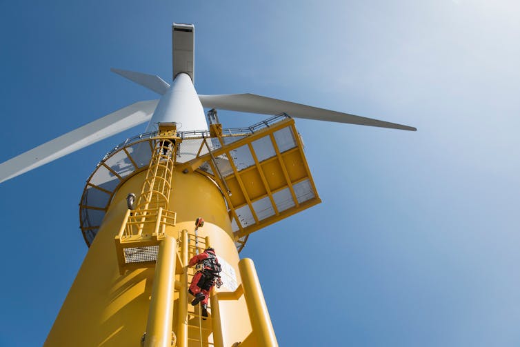 Technician climbs offshore wind turbine