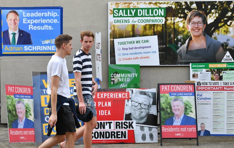 Young men walk past a polling station.