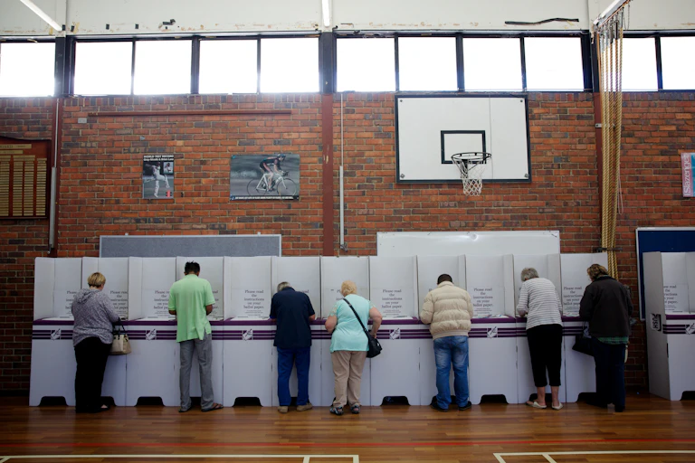 People with backs turned at the polling booth.