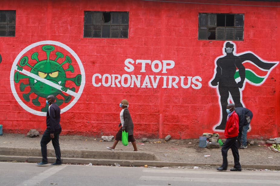 Kenyans walk past an informative mural about the Coronavirus along Haile Selassie avenue in Nairobi. 