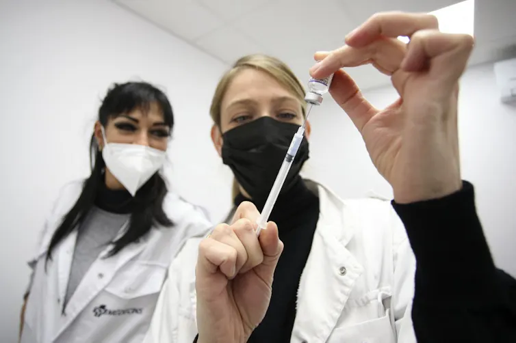 Préparation d’une injection de Pfizer par une médecin
