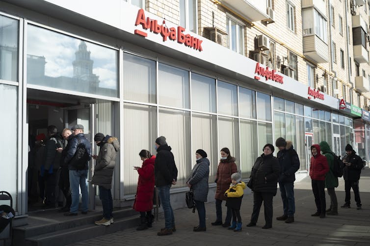 personnes font la file devant une banque
