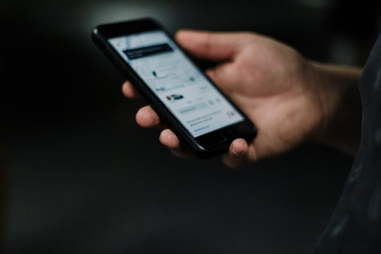 person holds phone with uber app on it