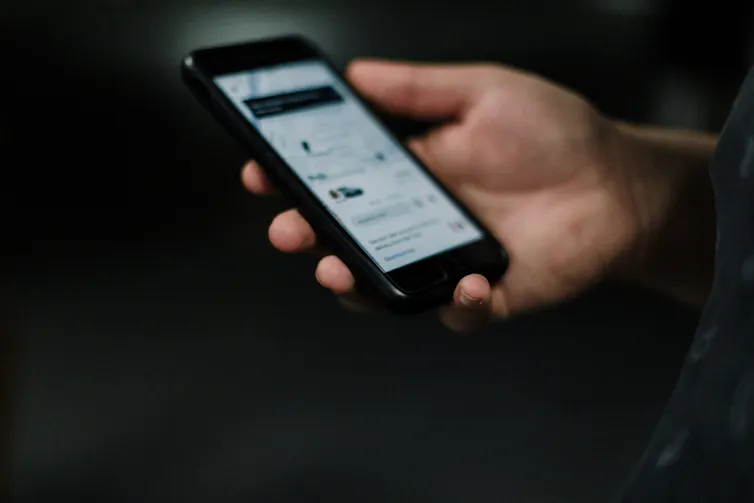 person holds phone with uber app on it