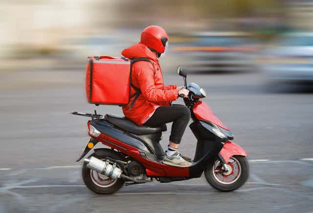 delivery driver on red scooter
