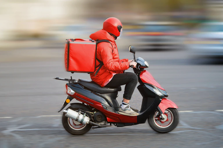 delivery driver on red scooter