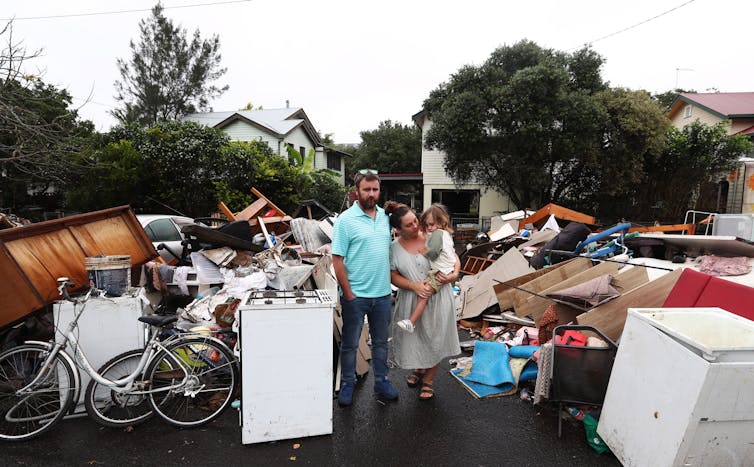 Lismore residents Tim Fry and Zara Coronakes and son Ezekiel outside their home on March 11 2022.