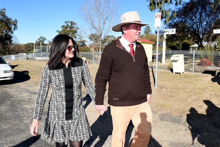 middle aged man and women walk holding hands