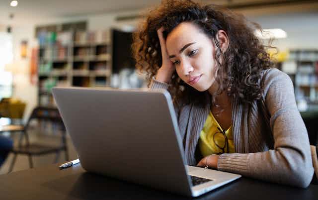 girl looks bored at computer