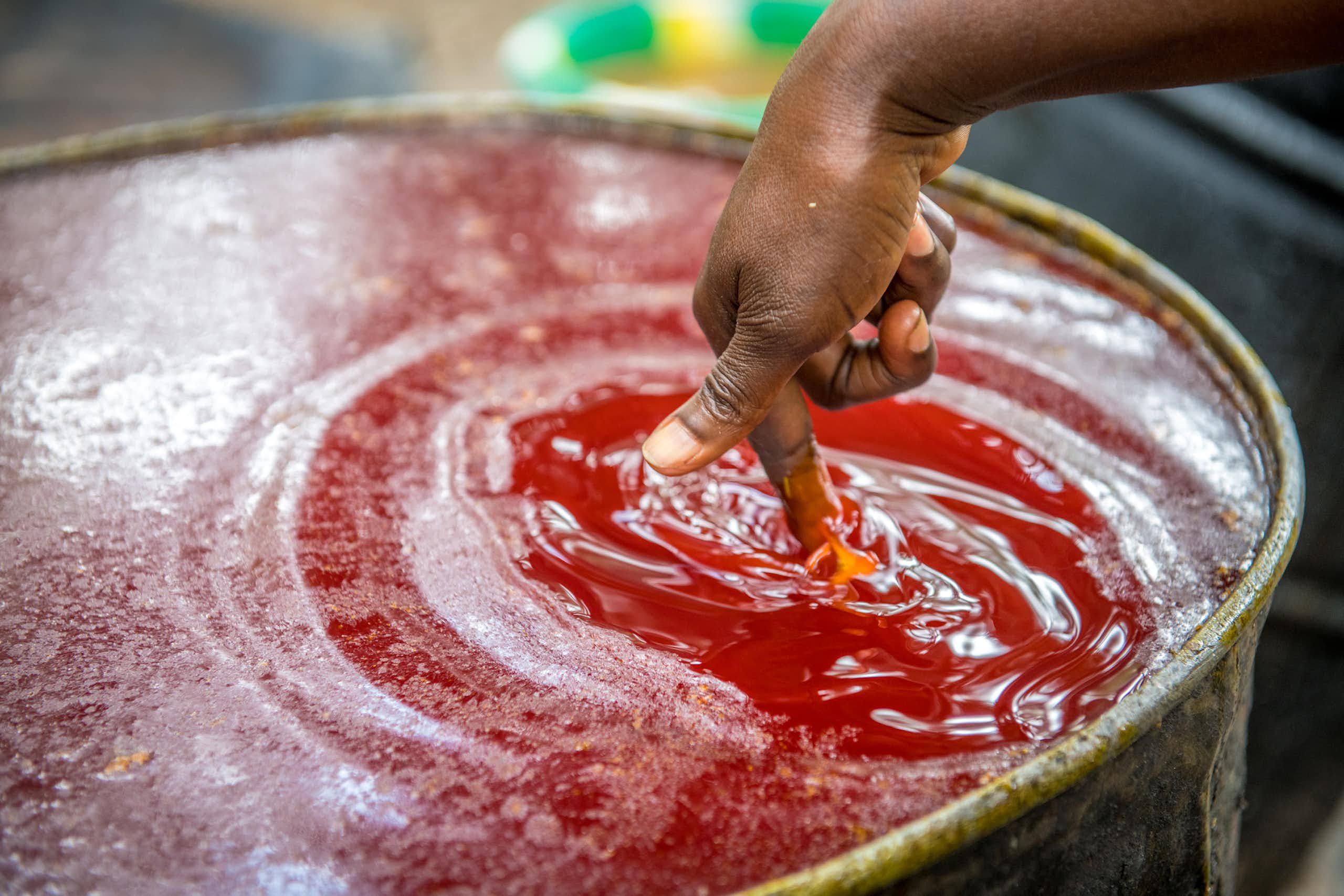 A person dips a finger in a tub of palm oil Nimba County, Liberia