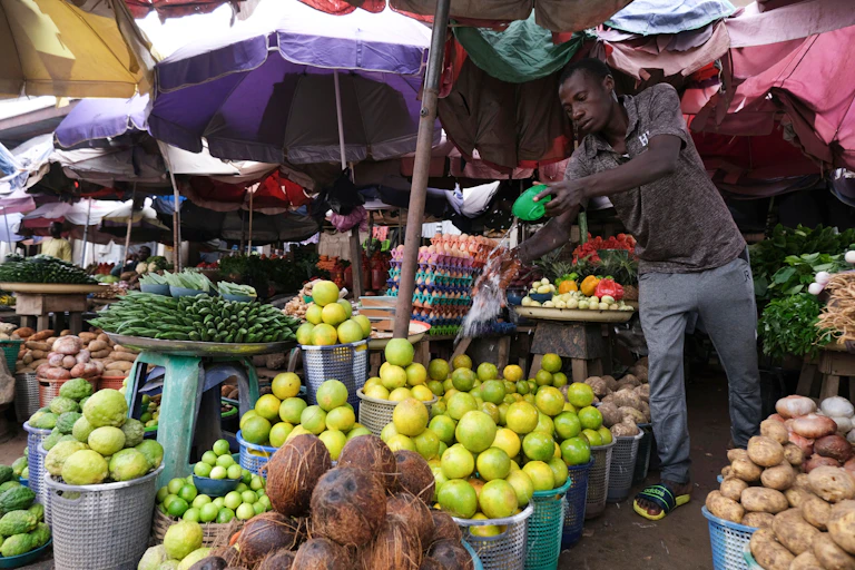 A man watching over his stall in an open market