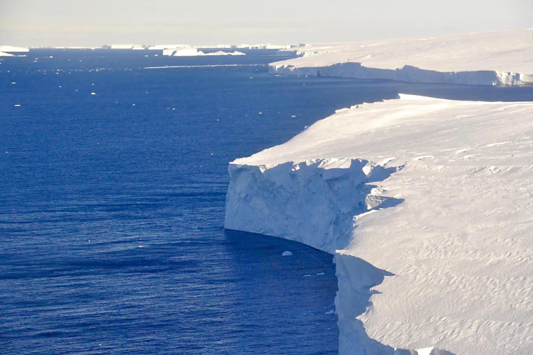 A jagged ice cliff meets open water
