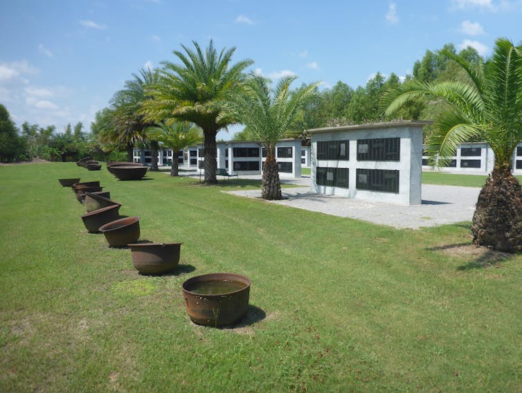 Large marble tablets are set along a green pasture.