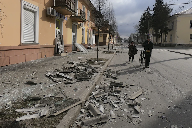 Two people walk along a street destroyed by shelling in Chernihiv, northern Ukraine