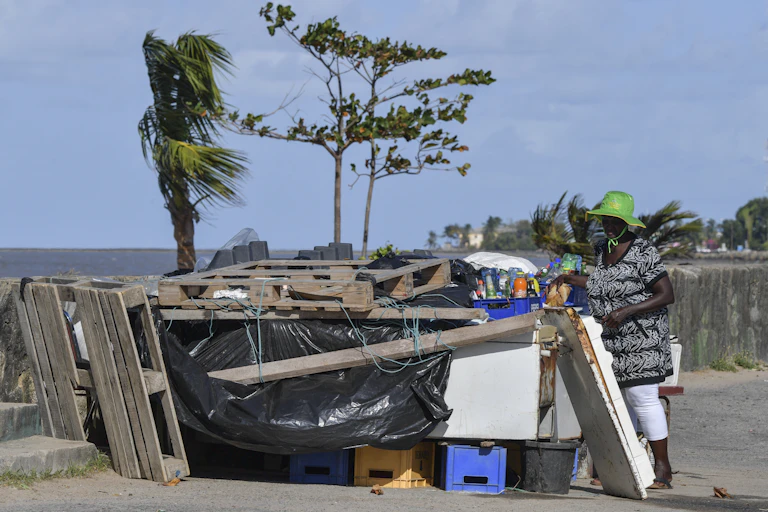 Woman at a stand made of scrap lumber near the ocean