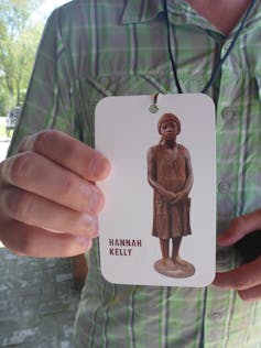 A man holds up a photo of an enslaved woman named Hannah Kelly