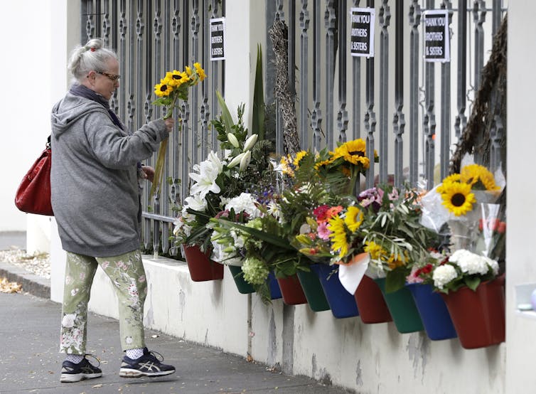A woman placing flowers in a Christchurch memorial.