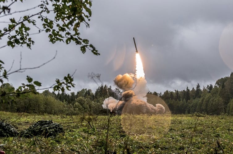 An Iskander missile shoots upwards in a field in Russia.