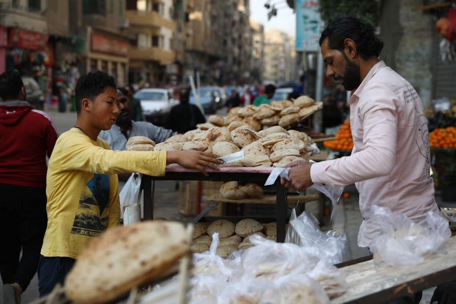 A boy buys bread at a market in Cairo.