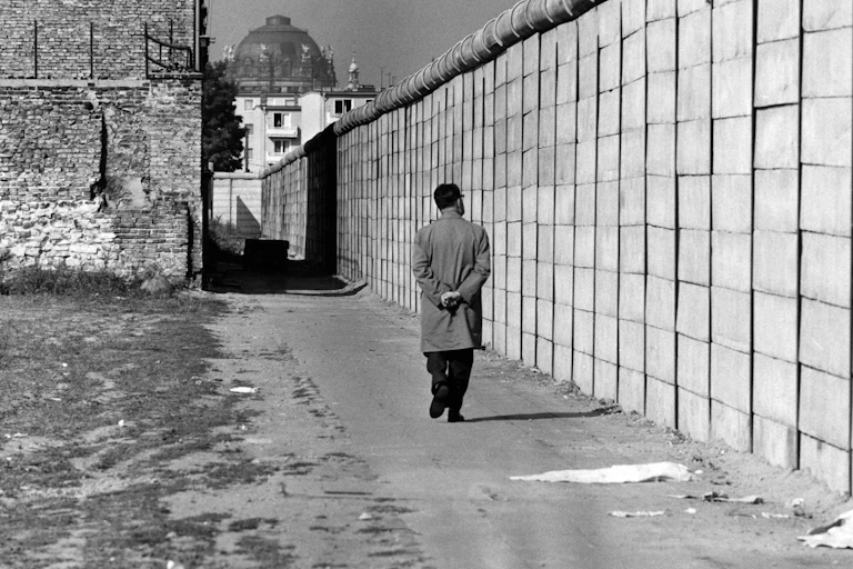 A man walks past the Berlin Wall.
