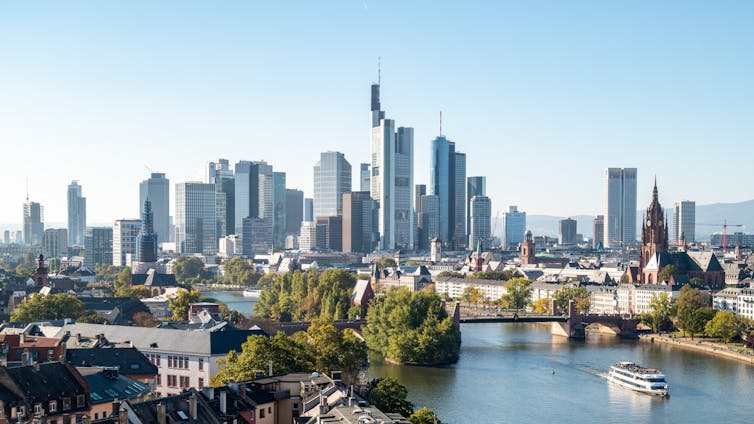 A city skyline under a pale blue sky.