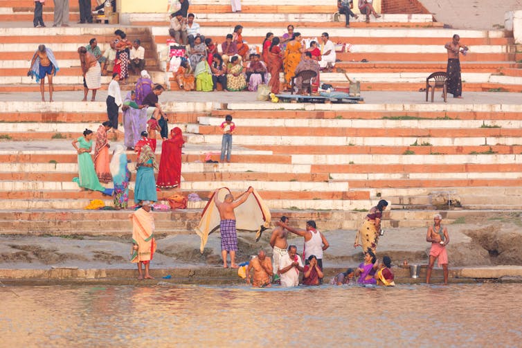 People on steps leading into the river.