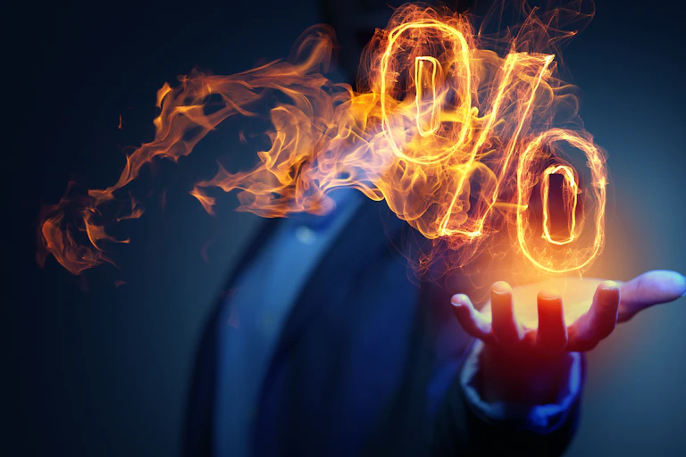 A man with his hand out and a flaming percentage sign above his palm