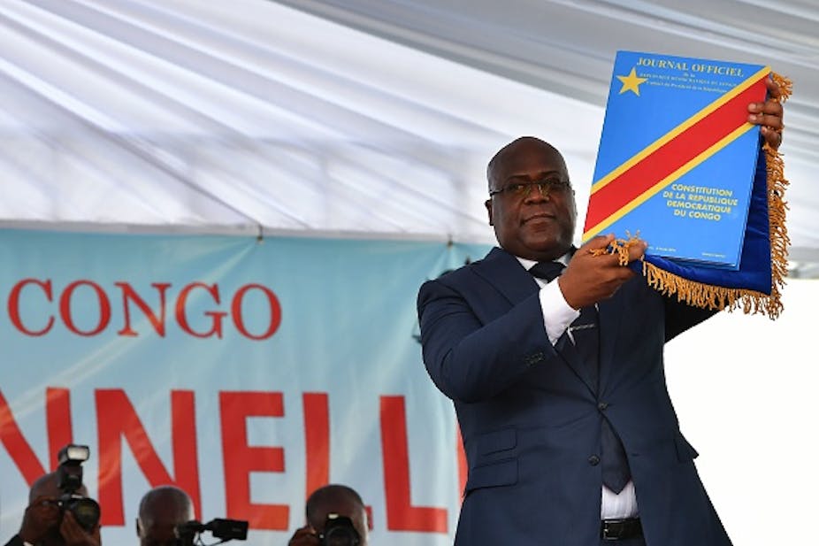DRC President Felix Tshisekedi waves an official copy of the nation's constitution 